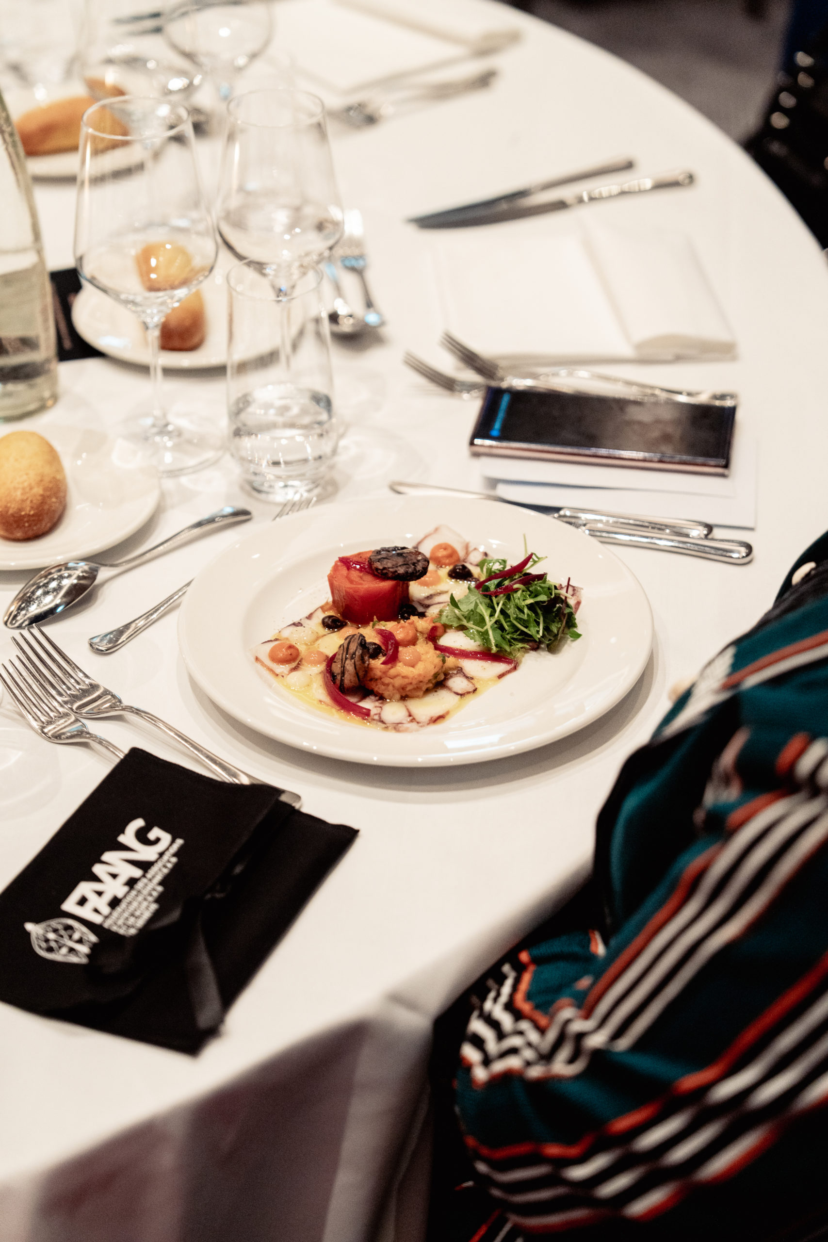 Table dressée lors du Gala FAANG 2025 avec le menu du chef et une pochette FAANG.